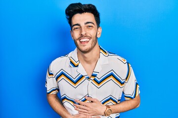 Young hispanic man wearing casual clothes smiling and laughing hard out loud because funny crazy...