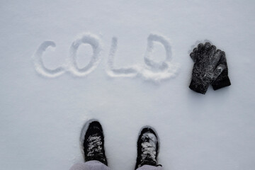 the guy wrote in the winter in the snow cold. winter inscription on the snow with warm gloves. cold season