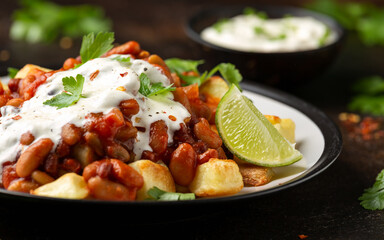 Spicy Bean Chilli with Baked Potato, sour cream and lime. Healthy Food