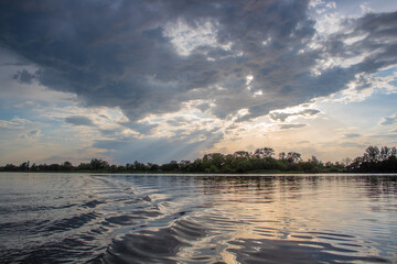 Cloudy sunset on the river, calm, water surface