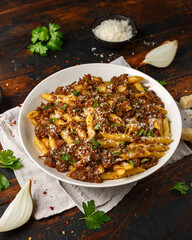 Pasta alla Genovese on a white bowl with parmesan cheese. Traditional neapolitan food.