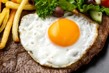 Portugal dish Bitoque made from beef steak with a fried egg, rice, french fries and vegetables