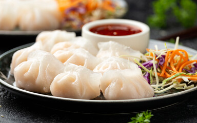 Traditional Asian Prawn or shrimp dumplings hakau, ha kauw or har gow. Served with cabbage, carrot salad and soy and sweet chilli sauce