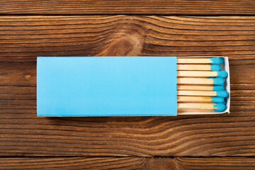 top view blue color matchbox with blue match sticks on a wood table