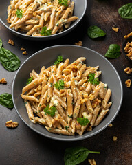 Whole Wheat Penne pasta with gorgonzola cheese sauce, spinach and walnut. Healthy food.