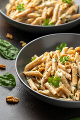Whole Wheat Penne pasta with gorgonzola cheese sauce, spinach and walnut. Healthy food.