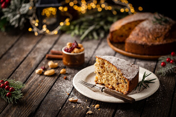 Traditional Christmas cake pudding with fruits and nuts with Christmas decorations, dark background