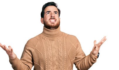 Young hispanic man wearing casual clothes crazy and mad shouting and yelling with aggressive expression and arms raised. frustration concept.