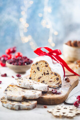 Fototapeta na wymiar Christmas Stollen. Traditional Sweet Fruit Loaf with Icing Sugar. Xmas holiday table setting.