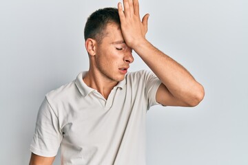 Young caucasian man wearing casual white polo surprised with hand on head for mistake, remember error. forgot, bad memory concept.