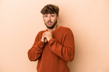 Young arab man isolated on beige background scared and afraid.