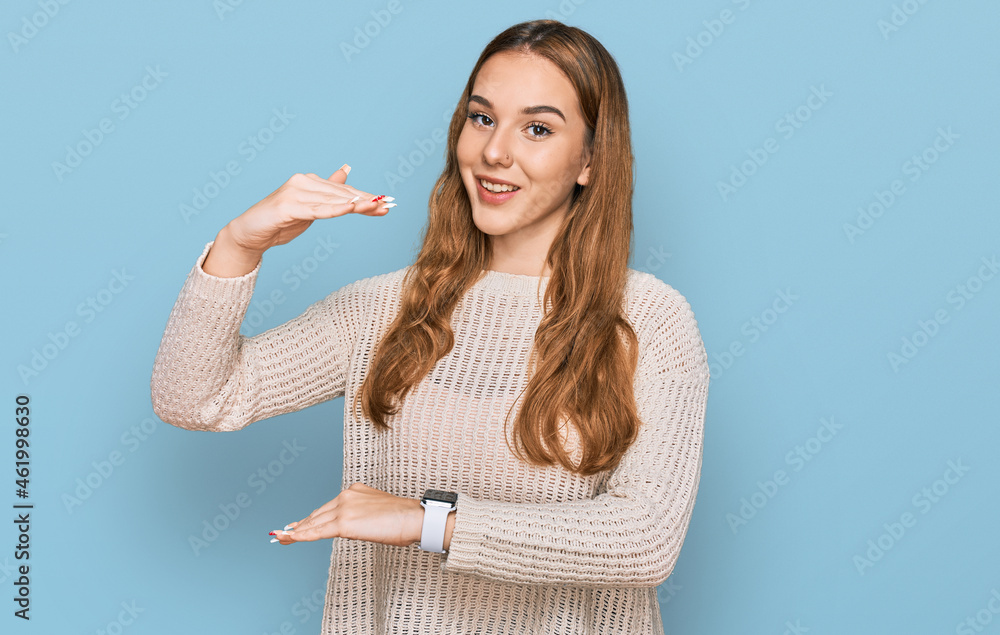 Sticker young blonde woman wearing casual clothes gesturing with hands showing big and large size sign, meas