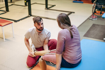 Physiotherapist helping young woman with prosthetic legs
