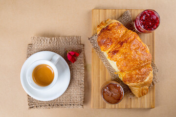 Fresh baked croissant with raspberry jam , chocolate and espresso coffee , sweet tasty breakfast