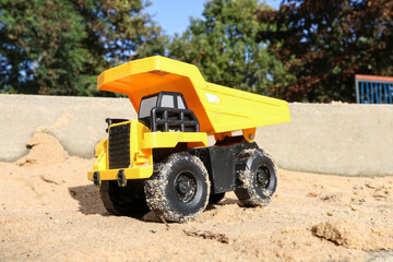 Toy tonka truck in a sandpit.