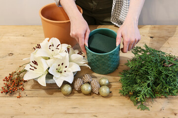 Christmas floral arrangement with white lilies, thuja twigs and golden baubles, tutorial.