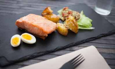 steamed salmon fillet with potato wedges, guacamole homemade and quail egg