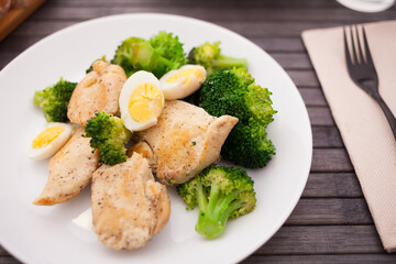 chicken breast with broccoli and quail eggs on plate for healthy dinner