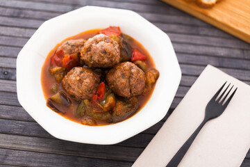 cooked meatballs with stewed eggplant in bowl
