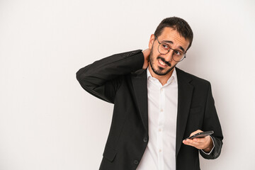 Young business man holding a mobile phone isolated on white background touching back of head,...