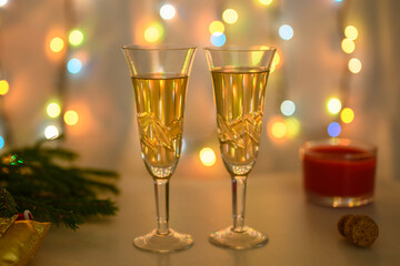 Glasses against the background of a luminous garland are prepared for the New Year.