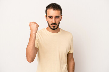 Young caucasian man isolated on white background showing fist to camera, aggressive facial...
