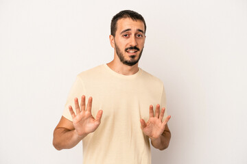 Young caucasian man isolated on white background rejecting someone showing a gesture of disgust.