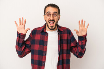 Fototapeta premium Young caucasian man isolated on white background receiving a pleasant surprise, excited and raising hands.
