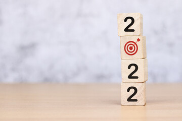 Happy New Year. Wooden cube with 2022 goal icon, concept to success of growing business.