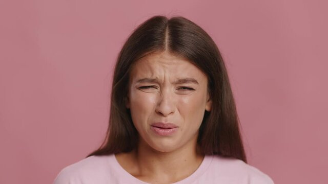 Disgusted Woman Frowning Feeling Stinky Smell Posing Over Pink Background