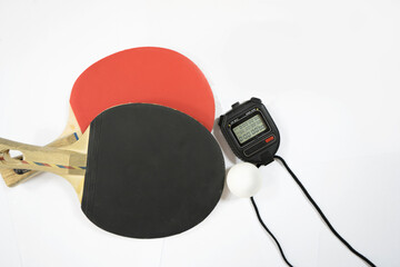 Table tennis rackets, stopwatch and ping pong balls on a white background