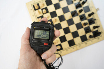 One person arranges white chess pieces on a wooden board. Brain-developing games