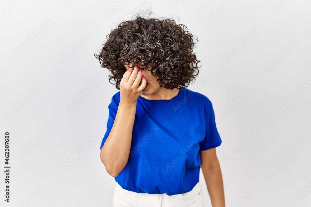 Sticker Young middle eastern woman standing over isolated background tired rubbing nose and eyes feeling fatigue and headache. stress and frustration concept.