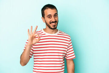 Fototapeta premium Young caucasian man isolated on blue background cheerful and confident showing ok gesture.