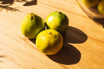 Yellow green Mandarin oranges on a wooden background in an artistic view
