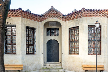An old building with a window and a door made of iron.