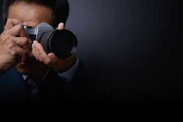 professional male photographer shooting indoor on vitage camera