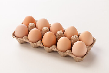 chicken eggs in carton on white background.