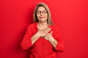 Middle age hispanic woman wearing casual clothes and glasses smiling with hands on chest with closed eyes and grateful gesture on face. health concept.
