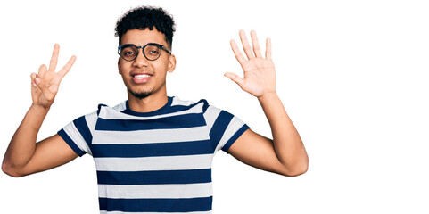 Young african american man wearing casual clothes and glasses showing and pointing up with fingers number seven while smiling confident and happy.