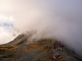 ガスがかかる北アルプス一の越山荘の早朝の風景