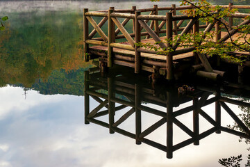 View of bridge and lake made of wood in autumn.
