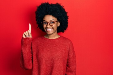 Fototapeta na wymiar Young african american woman wearing casual clothes and glasses smiling with an idea or question pointing finger up with happy face, number one