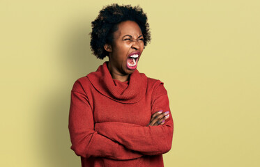 Fototapeta na wymiar African american woman with afro hair with arms crossed gesture angry and mad screaming frustrated and furious, shouting with anger. rage and aggressive concept.