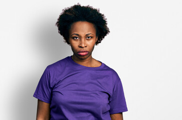 African american woman with afro hair wearing casual purple t shirt skeptic and nervous, frowning upset because of problem. negative person.