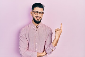 Naklejka premium Handsome man with beard wearing casual shirt and glasses smiling happy pointing with hand and finger to the side