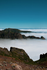 Fototapeta na wymiar Huge mountains and hills above clouds in Pico do Arieiro at Madeira Island
