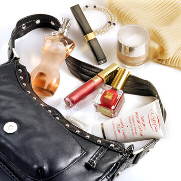 Barcelona-Spain-Circa October 2015- Woman bag with cosmetics and perfumery goods in fine still life. Visible brands JP Gautier perfume, Estee Lauder nail polish, C Chanel, Clarins and Kanebo cream