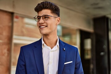 Young man smiling confident wearing suit and glasses at street