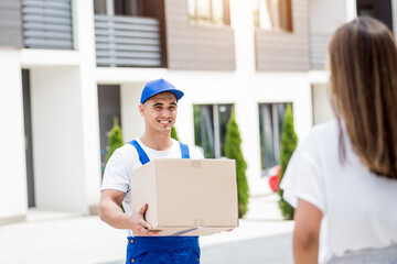 Young courier delivering goods to a young woman at home